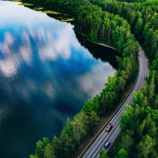 Aerial,View,Of,Road,Between,Green,Summer,Forest,And,Blue