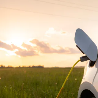 electriccarwithopenedchargingsocketcapandchargerplugged