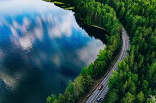 Aerial,View,Of,Road,Between,Green,Summer,Forest,And,Blue