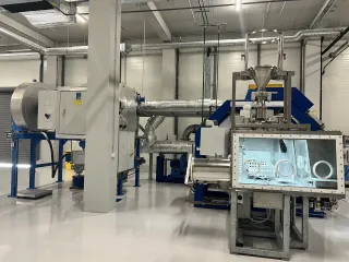 Interior of the ReLiFe pilot recycling plant in Xanthi, Greece, showing the deactivation furnace and processing equipment of the lithium recycling pilot line with blue and stainless-steel machinery in a clean industrial hall